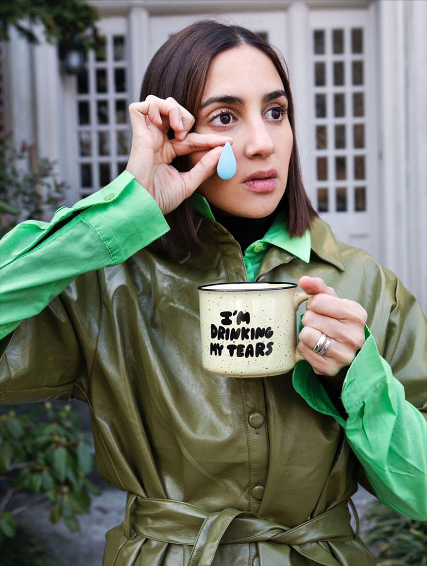 Female dressed in green holding a mug